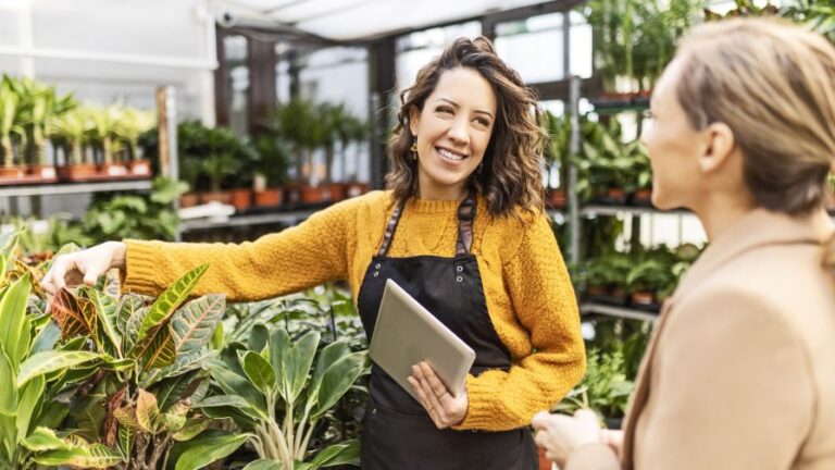 Woman at a garden center talking with an employee buying plants