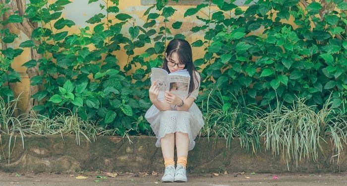image of asian woman reading outside.jpg.optimal